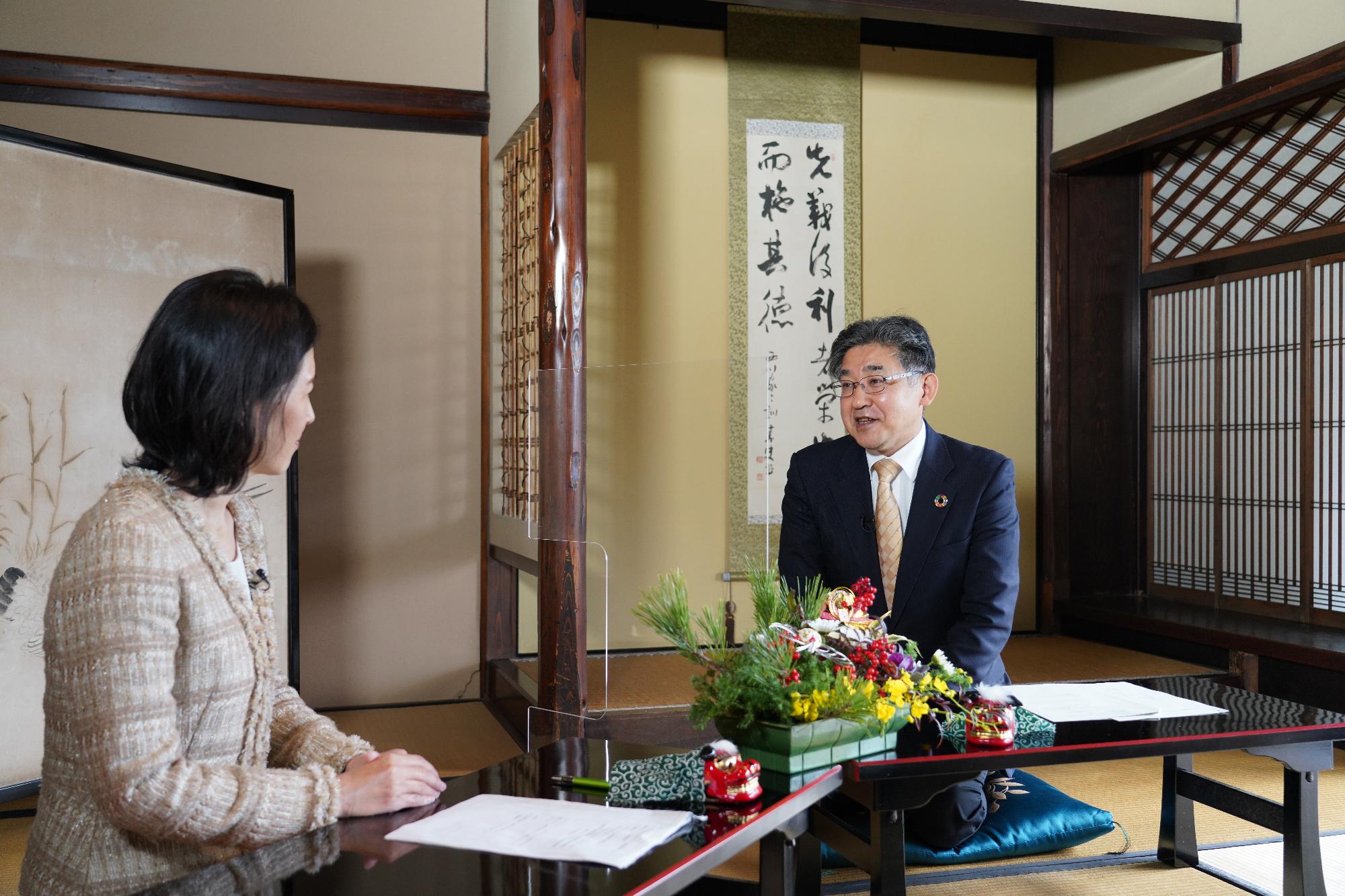 小西理市長と女性アナウンサーが向かい合って座り話をしている様子の小西市長新春トーク一場面の写真