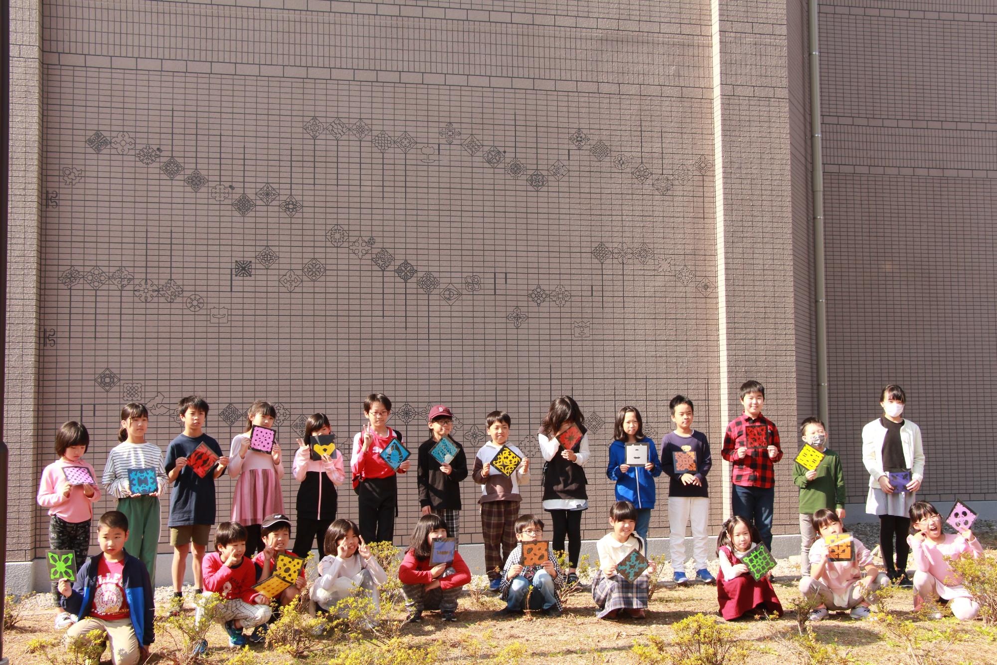 外壁アートの前で参加児童の記念撮影