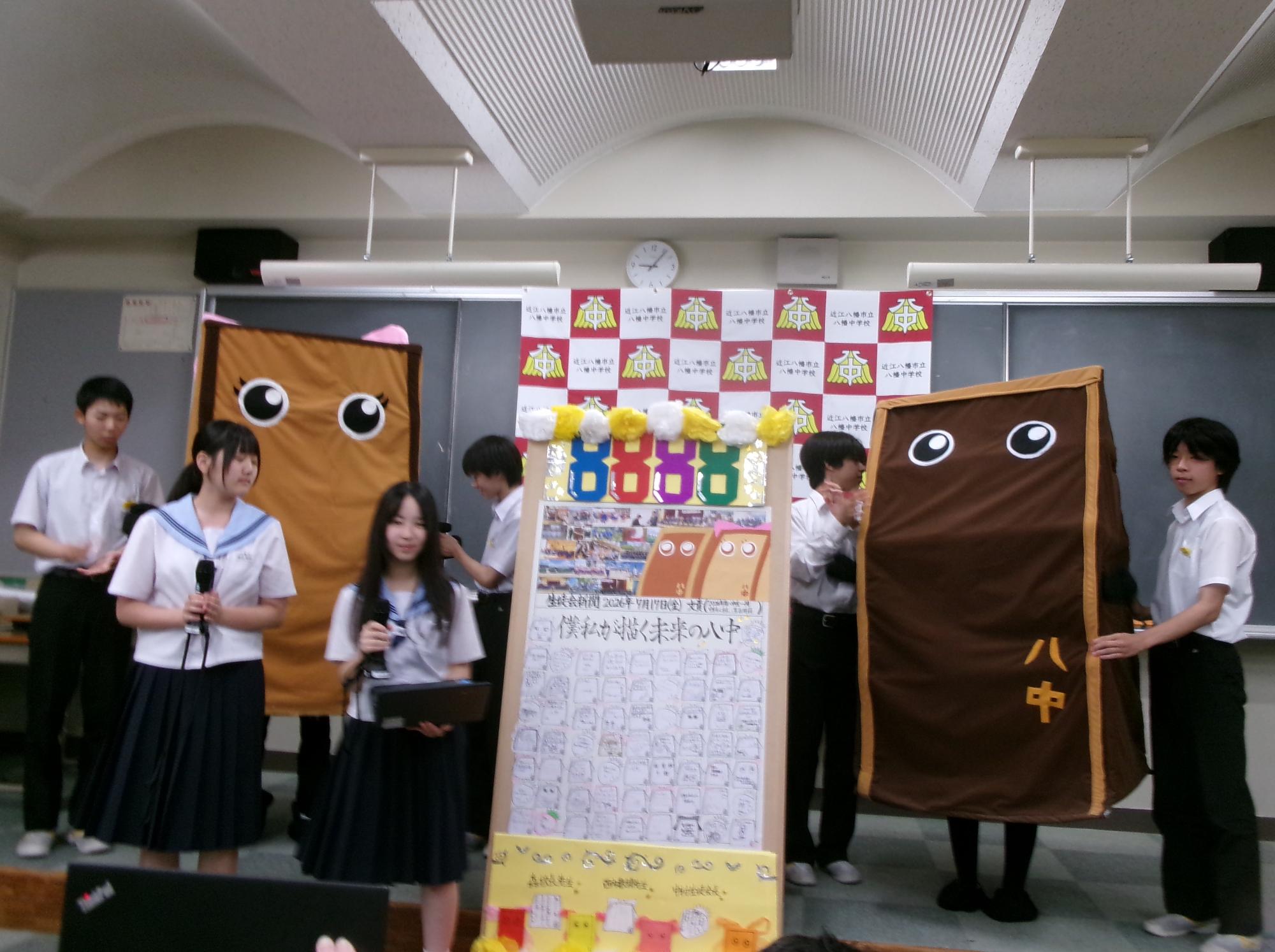 八幡中学校のゆるキャラでっちくんとでっちちゃんと一緒に写る生徒会メンバーの写真