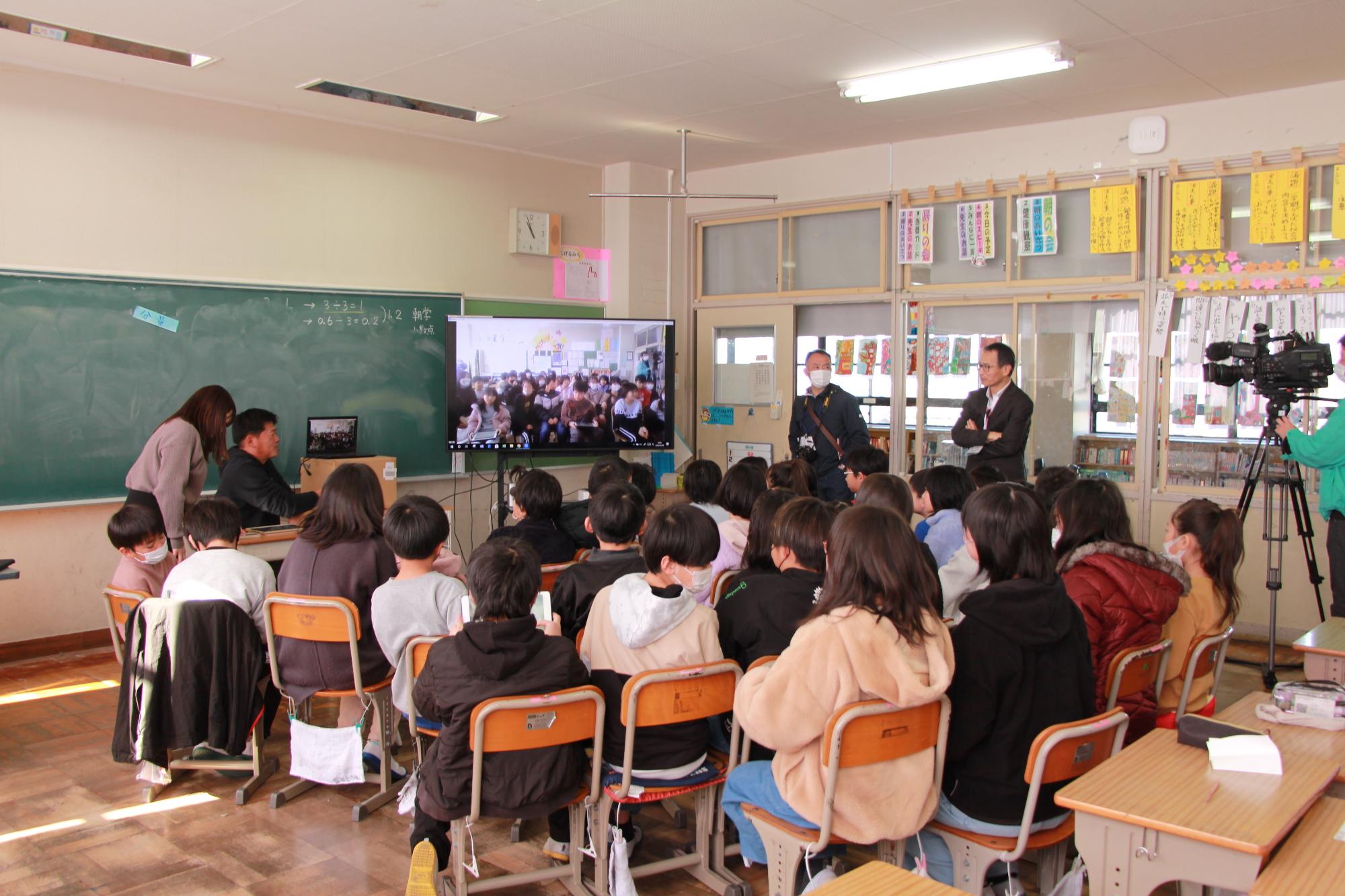 釧路市の武佐小学校とオンラインでつながっている画面を見る児童ら