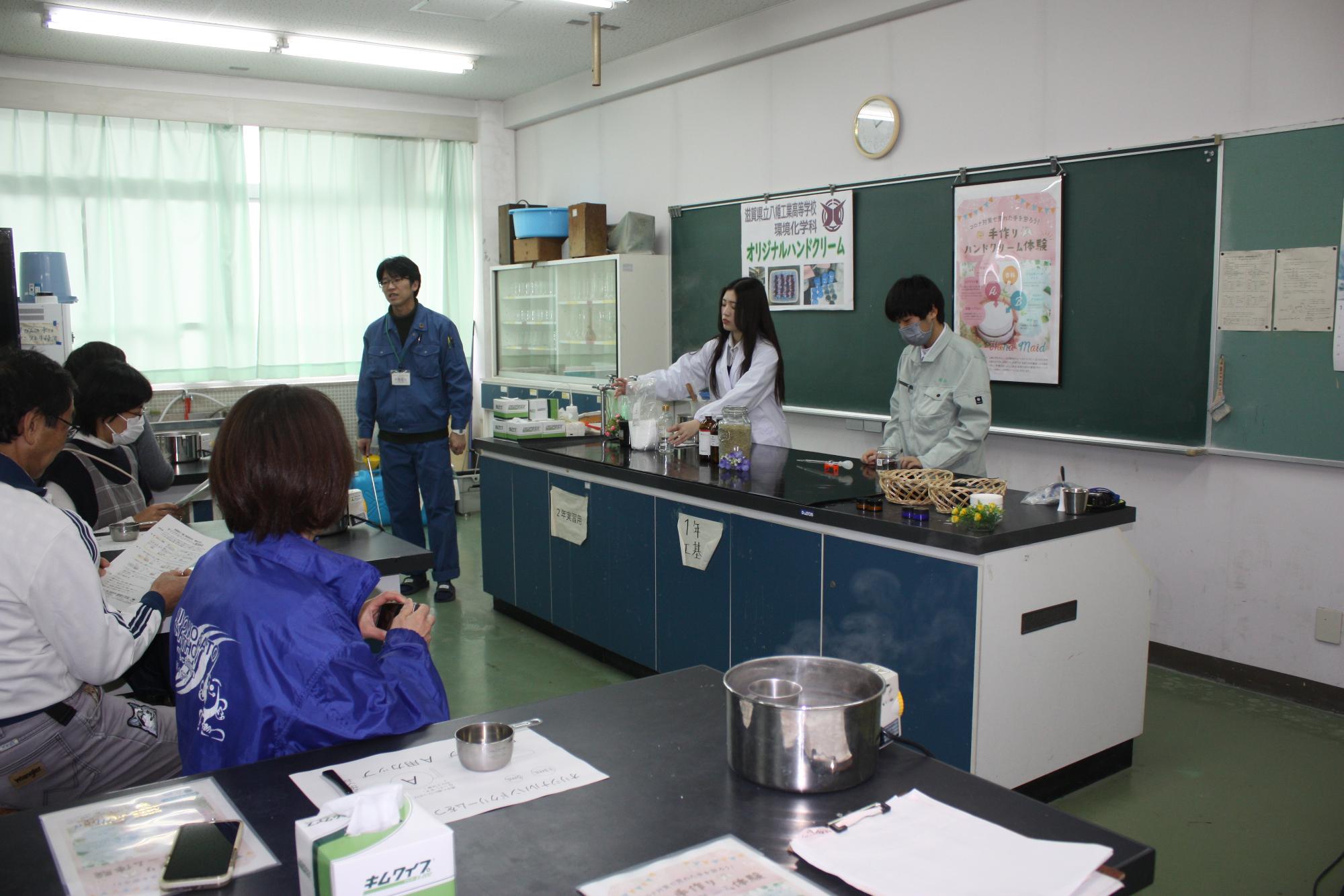 環境化学科教室で講師役の高校生から説明を受ける参加者