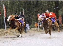 それぞれの馬を古式和装の人が勇壮に駆る2頭の馬の写真