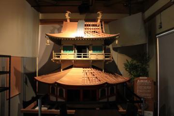 柔らかな照明が当たる安土城天主上層部7分の1雛型模型展示の写真