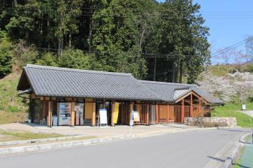 背景に緑の木々が茂る特別史跡安土城跡ガイダンス施設の全景写真