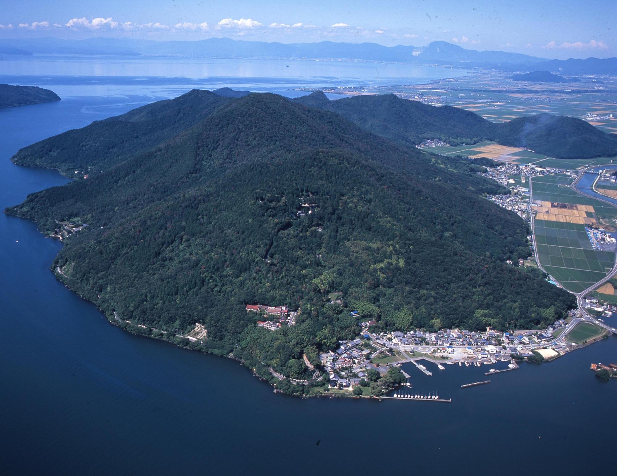 琵琶湖に迫る山並みや山裾の住宅地や田畑、船着き場などを上空から写した写真