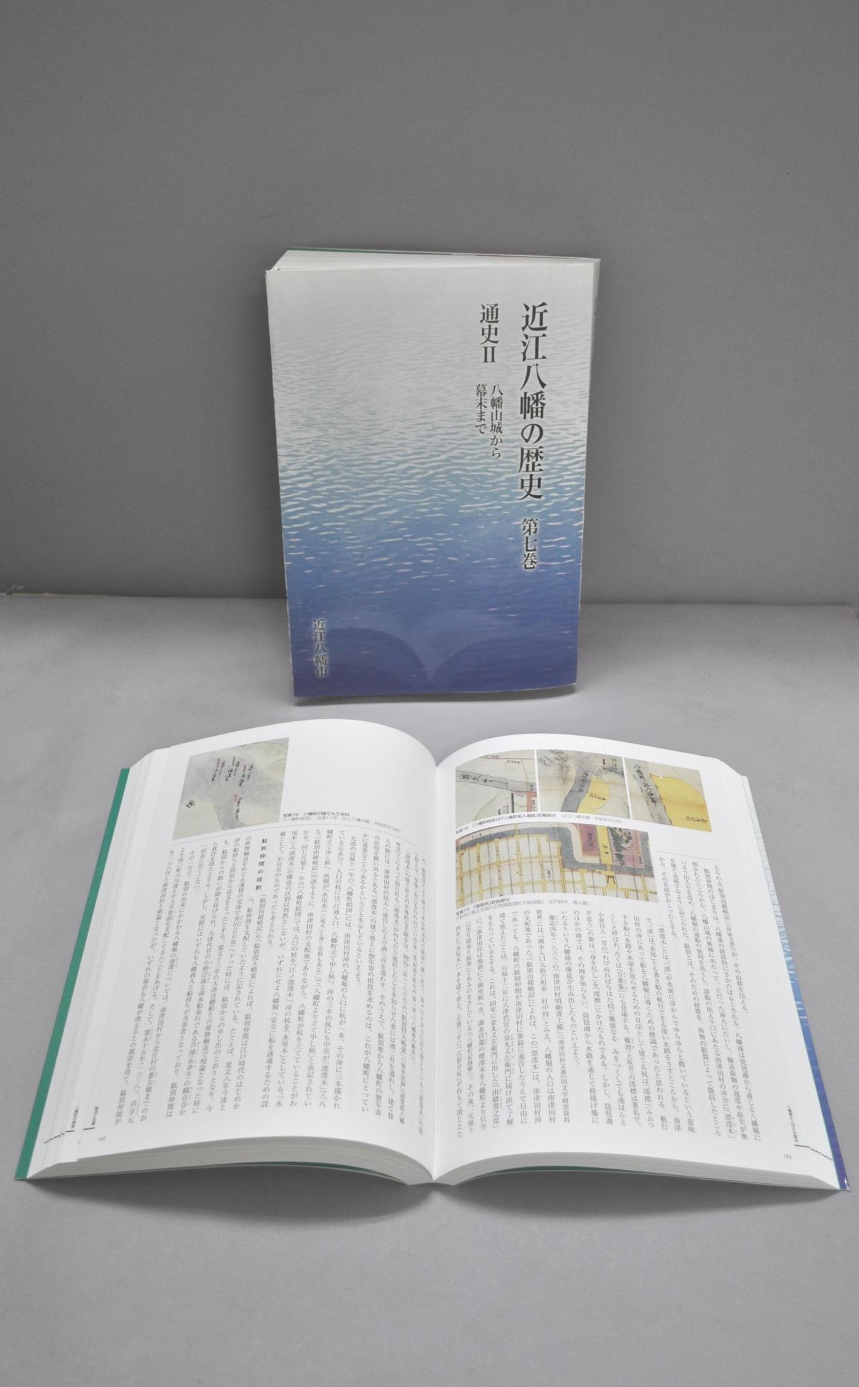 近江八幡の歴史第7巻を立てた表紙と、ページ中ほどを開いて手前に置かれた写真