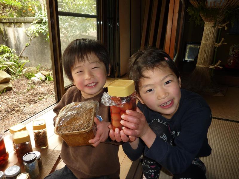手作りの食品を手にする岡さんの娘さんと息子さんの写真