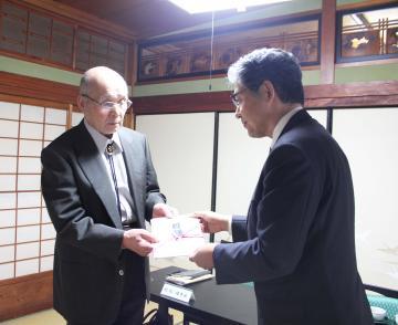 村松報恩会の男性より寄付を受け取る市長の写真