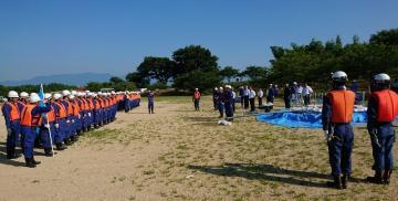 平成30年度 滋賀県消防協会八幡支部夏期訓練にて、青とオレンジの服をきて訓練を行う消防団員の写真