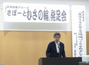 武佐学区生活支援グループ「さぽーとむさの輪」発足会にて、マイクで話す市長の写真