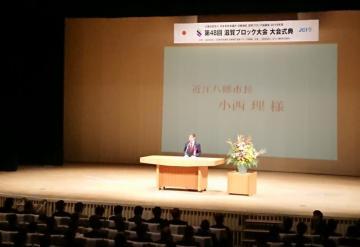 日本青年会議所 第48回滋賀ブロック大会近江八幡大会にて、着席する参加者の前で話す市長の写真