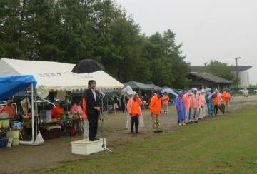 市総合スポーツ大会のゲートボール競技にて、雨の中、参加者を前に話す市長の写真