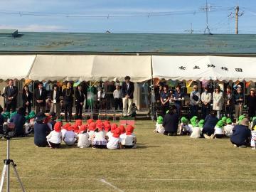 安土幼稚園運動会にて赤や緑の帽子を被り、その色ごとに分かれて座る園児を前に話す市長の写真