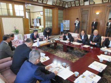 四角く並べられた机に座り、東近江市、野洲市、竜王町、日野町、近江八幡市の市長・町長、各市町議会議員の方々とともに、県知事等へ早期改修、予算確保の要望東近江市、野洲市、竜王町、日野町、近江八幡市の市長・町長、各市町議会議員の方々とともに、県知事等へ早期改修、予算確保の要望を行う市長の写真