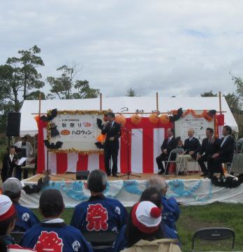 小舟木エコ村開村10周年記念式典 秋祭り・ハロウィンにて、着席する参加者の前で話す市長の写真