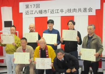 近江牛枝肉共進会にて、授与された賞状を胸に掲げる受賞者7名と市長の集合写真