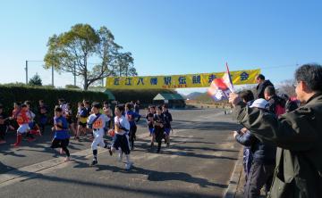 第65回近江八幡駅伝競走大会のスタート地点にて、スタートした選手らと、沿道で応援する人々の写真