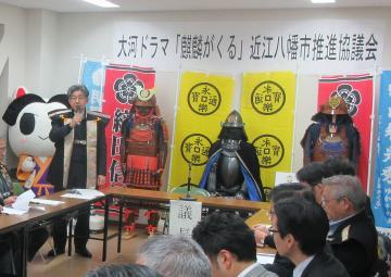 大河ドラマ「麒麟がくる」近江八幡市推進協議会にて、四角く並べられた机に着席する参加者の前で話す市長の写真