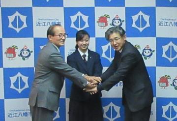 笑顔で握手を交わす、フィギュアスケートの滋賀代表選手の近江兄弟社中学校の長谷川桃香さんと市長の写真