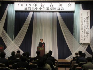滋賀県中小企業家同友会2019年新春例会にて、着席する参加者の前で話す市長の写真