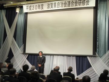 滋賀県自治会連合会研修会にて、着席する参加者の前で話す市長の写真