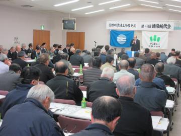 日野川流域土地改良区総代会にて、着席する参加者の前で話す市長の写真