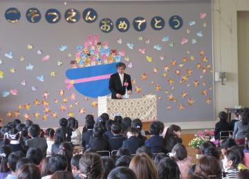 桐原幼稚園修了証書授与式にて、着席した卒園生たちの前で、壇上のマイクで話す市長の写真