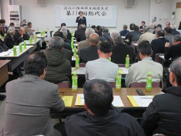 第111回西部土地改良区総代会にて着席した参加者を前にマイクを手に話す市長の写真