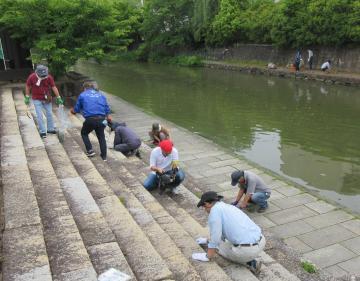 川辺で清掃活動する人たちの写真