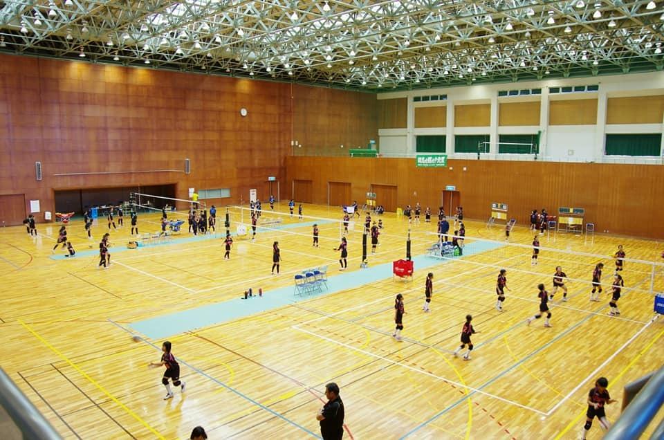 スポーツ少年団：室内にてバレーボールをしている様子を遠くから撮影した写真