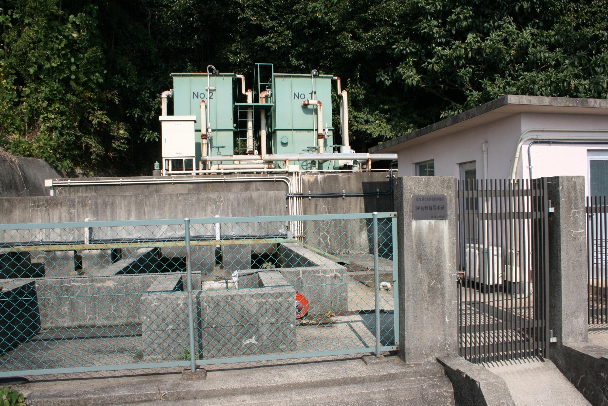 2台の取水ポンプが建物の隣に設置されている沖島浄水場の写真
