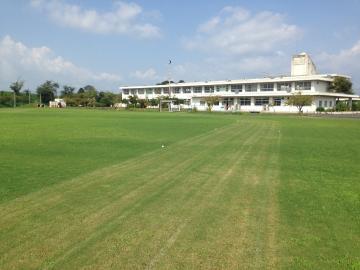 北里小学校の芝生の校庭から校舎を望む写真