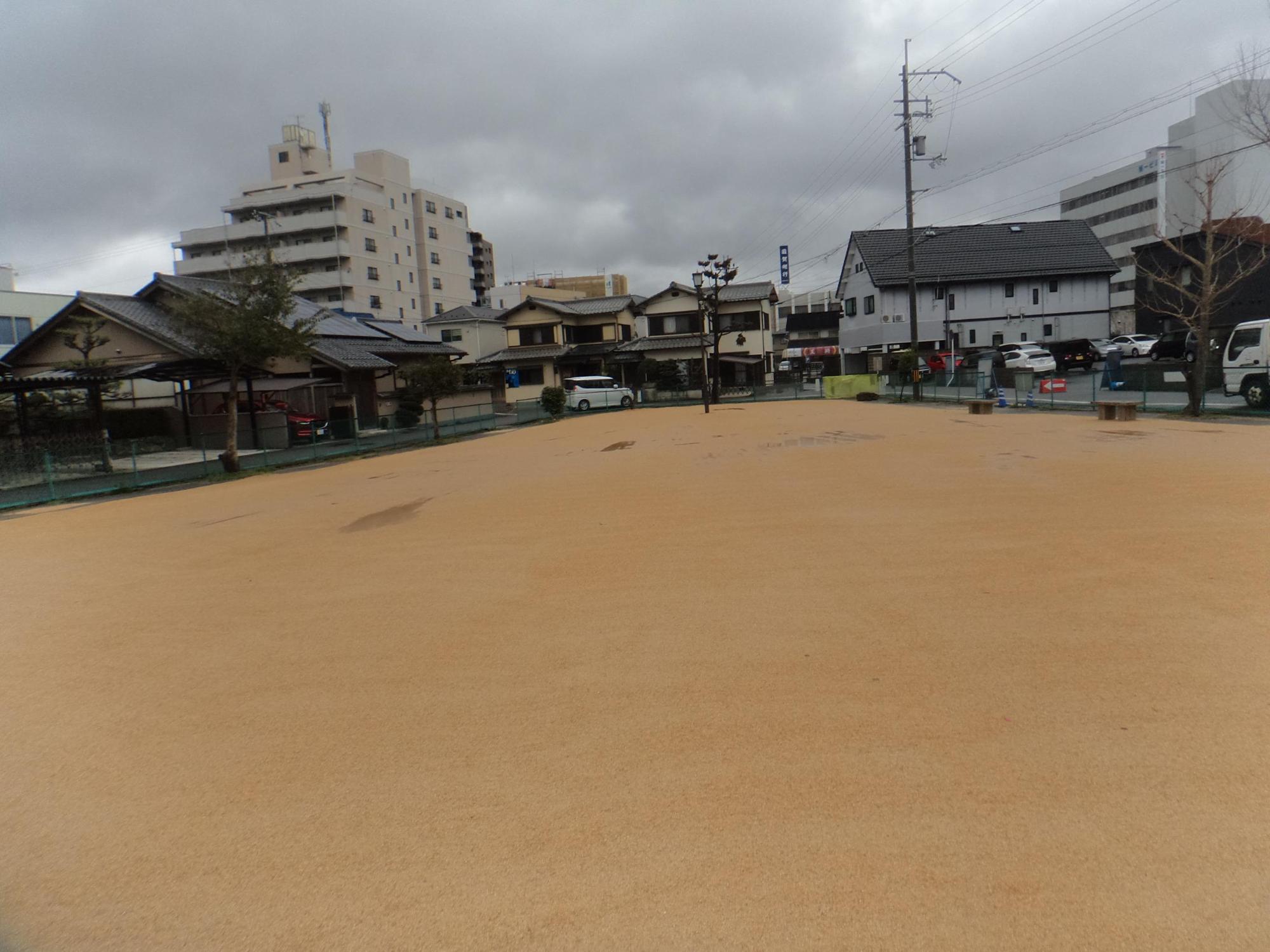 周りをフェンスで囲まれた広いグラウンドの駅前第3児童公園