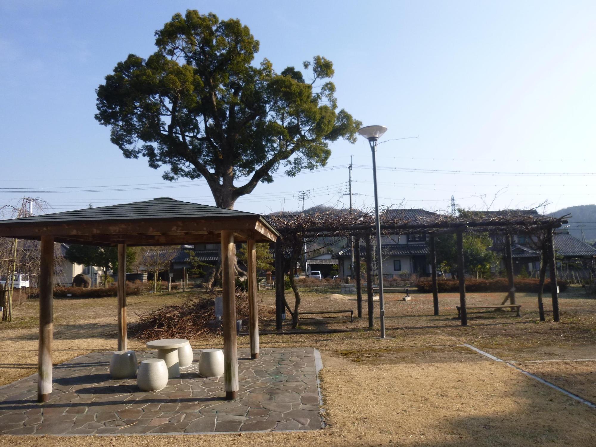大きな木といくつもの東屋のある西宿町公園の写真