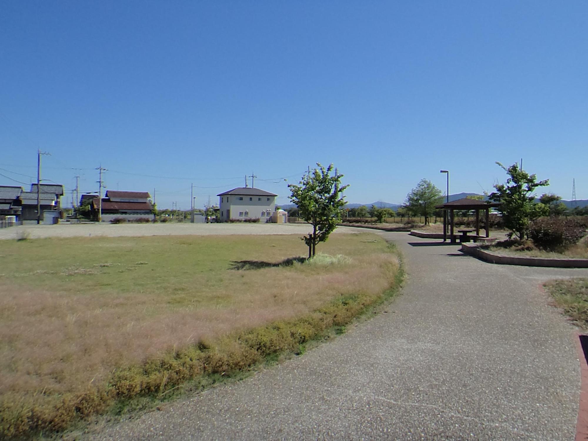 東屋のある広々とした芝生の上田町第1公園の写真